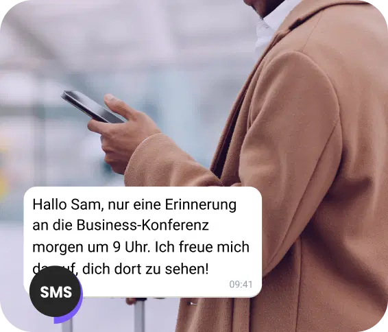 Ein Mann auf der Straße liest eine SMS mit einer Terminerinnerung.