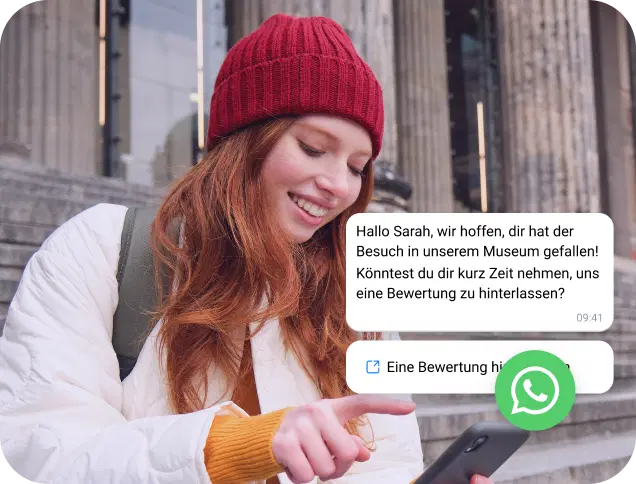 Ein Mädchen mit roter Mütze liest eine WhatsApp-Nachricht auf ihrem Smartphone.