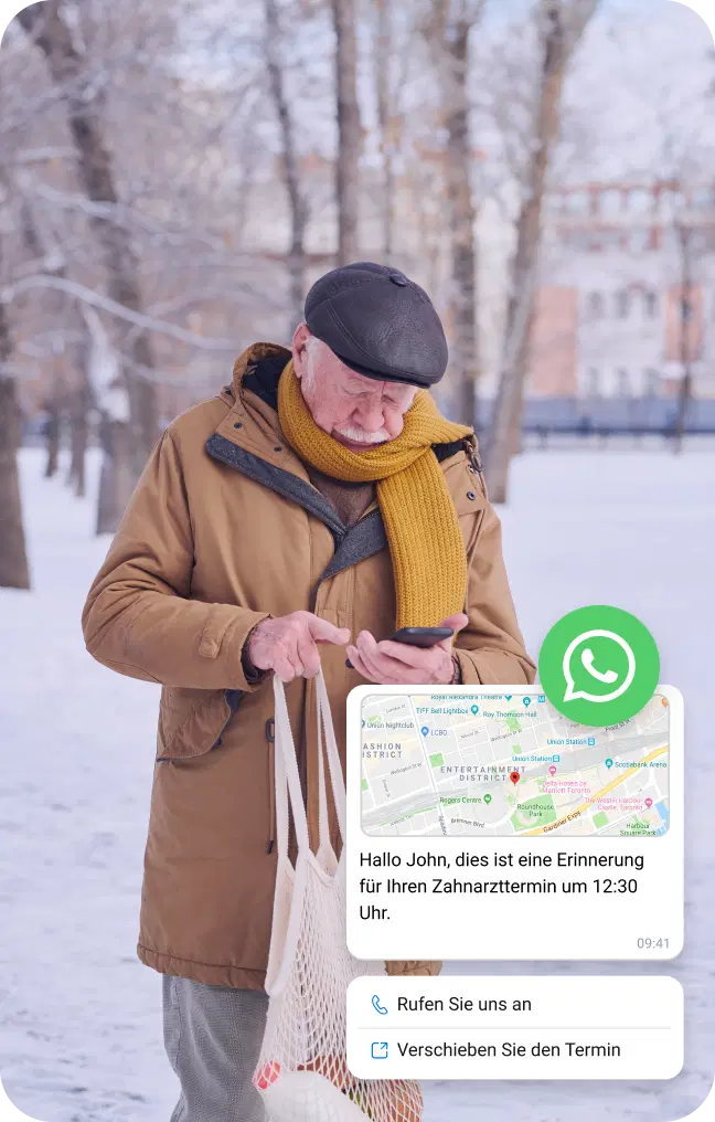 Ein älterer Mann überprüft eine WhatsApp-Nachricht mit Standortinformationen, während er im Schnee steht.