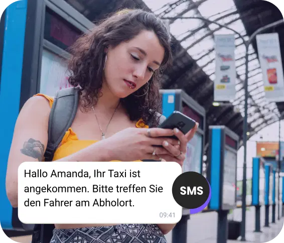 Am Bahnhof überprüft ein Mädchen mit Rucksack eine SMS zu ihrer Taxiankunft.