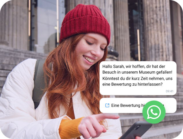 Ein Mädchen mit roter Mütze liest eine WhatsApp-Nachricht auf ihrem Smartphone.