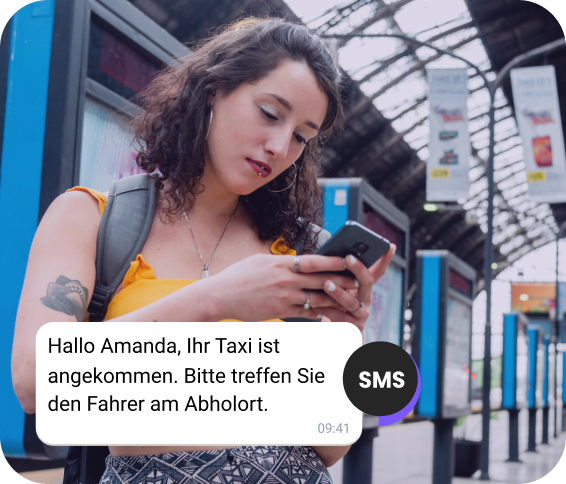 Am Bahnhof überprüft ein Mädchen mit Rucksack eine SMS zu ihrer Taxiankunft.