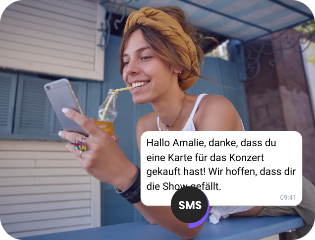 Ein Mädchen genießt einen Saft auf der Straße und liest eine SMS-Bestätigung für ein Konzertticket.