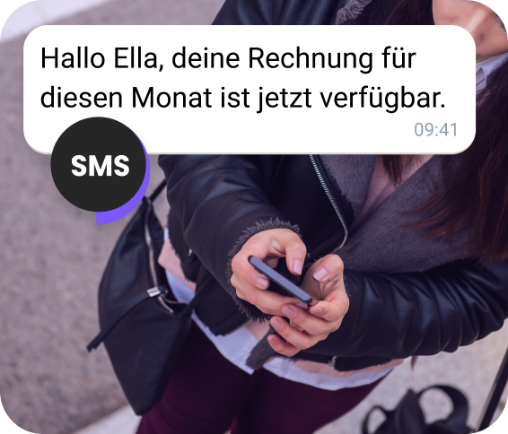 Eine junge Frau erhält eine Abrechnungs-SMS, während sie auf der Straße unterwegs ist.